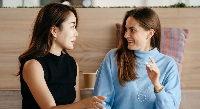 Una imagen de dos mujeres conversando, comunicándose activamente entre ellas.